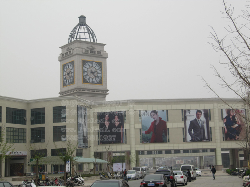 一個(gè)樓頂上的四面歐式塔鐘，外方內(nèi)圓，羅馬刻度，鐘盤(pán)內(nèi)飾以層層疊疊的金色花瓣形狀，美輪美奐